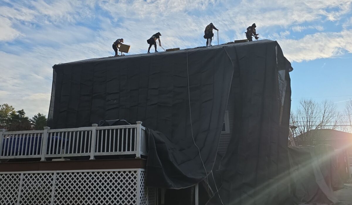 jasmor roofing crew on installation day - image of roof and home siding well protected